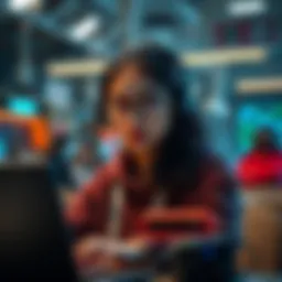 A young woman in a university setting looking for teammates for a hackathon, surrounded by laptops and tech tools.