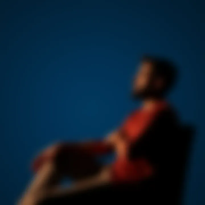 A man sitting thoughtfully, considering his body image and self-esteem, with a calm background.